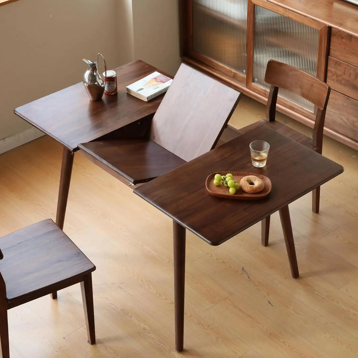 Astoria Collection | Tapered-Leg Atomic-Era Expandable Oak Dining Table - revealing tonal warmth and surface patina under ambient light in a Mid-Century Modern dining room setting.