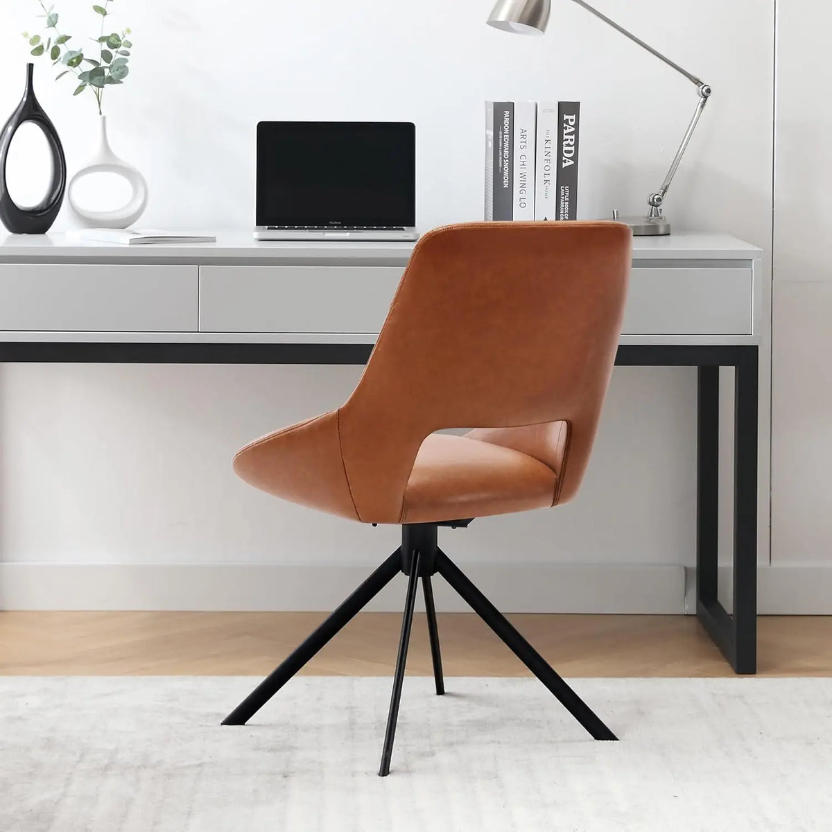 Ellington Collection | Sculptural Leather-Wrapped Swivel in Cognac Faux Leather - styled from an alternate angle revealing dimensional depth in a Mid-Century Modern living room setting.
