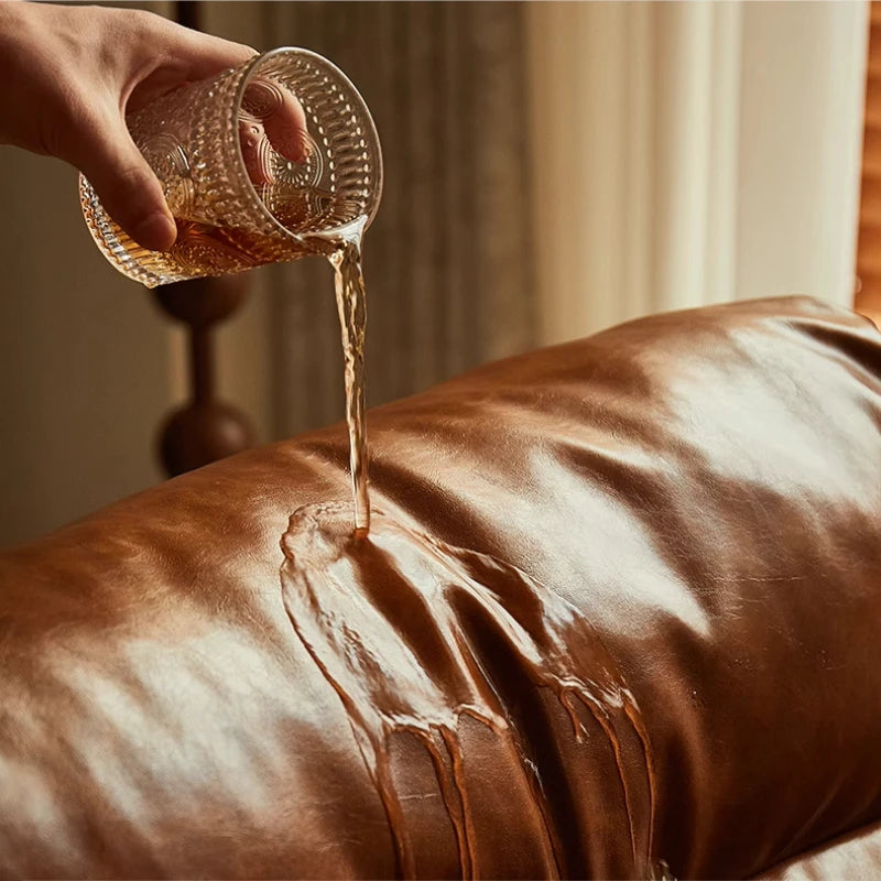 Ellington Collection | Glass-Topped Atomic-Era Cognac Leather Lounge - framed in an editorial still-life composition in a Mid-Century Modern living room setting.